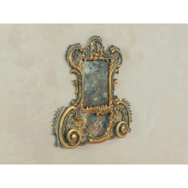 Hand-carved Baroque-style mirror from the 1960s. High-quality wooden body decorated with curved gold ornaments and...