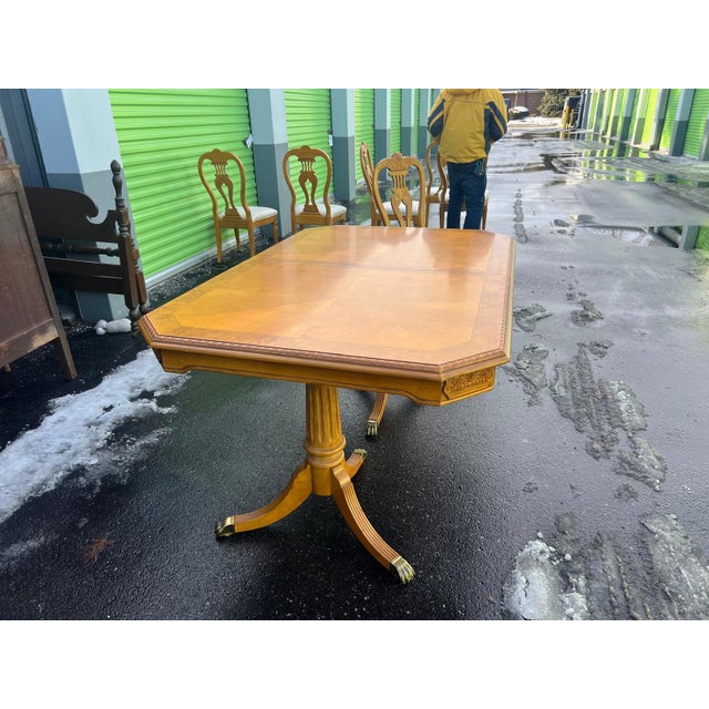 This elegant vintage dining set features a beautifully crafted wood dining table paired with six matching chairs. The...