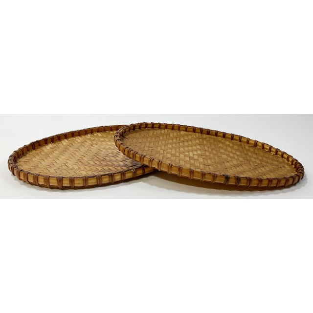 Vintage oval shaped wicker nesting trays with nice herringbone woven pattern. Framed in sturdy split rattan. Smaller tray...