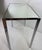 This is a mid-century vintage chrome and mirrored topped side table. This vintage table has a minimal design with a...
