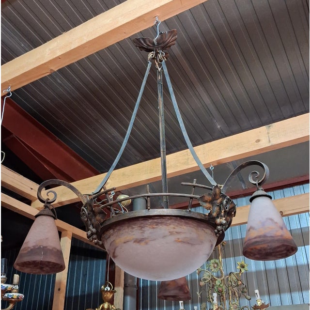 Degué: a substantial art nouveau wrought iron chandelier, dating from the early 20th century, featuring an elegant...