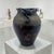 A sculptural studio pottery vessel defined by its architectural rim and restrained material palette. Hand-thrown in...