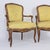 Pair of Louis XV Style chairs, each featuring an elegant, flowing walnut frame adorned with delicate floral carving,...