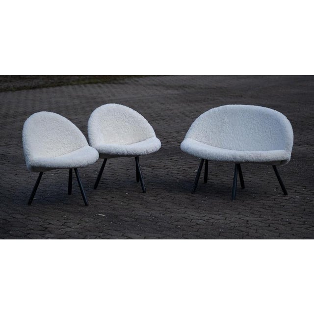Elegant mid-century set comprising a sofa and two armchairs, newly reupholstered in soft Gotland wool. The furniture...