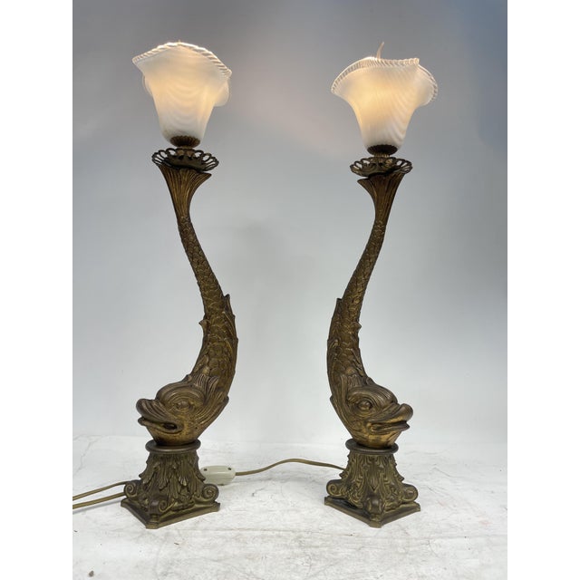 Beautiful pair of golden brass table lamps, in perfect 1920s Art Nouveau style; depicting two mythological fish, with...