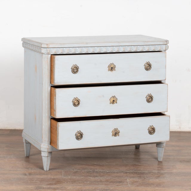 Gustavian style blue painted pine chest of three drawers with carved details along top resting on tapered feet. Newer...