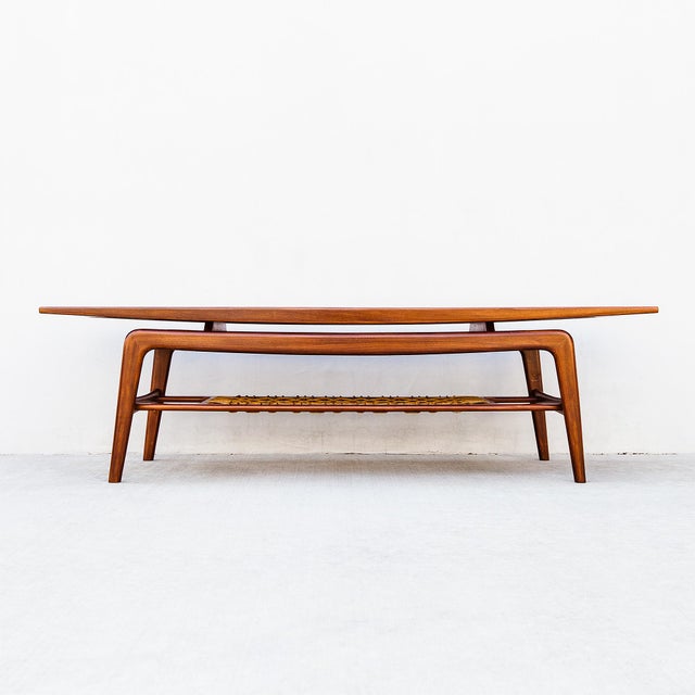 Vintage mid century sculpted teak coffee or cocktail table with woven magazine shelf, attributed to Arne Hovmand Olsen for...