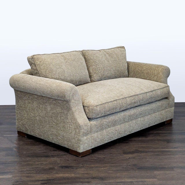 This loveseat features a classic design with rolled arms and soft, patterned upholstery. The wide seat and cushioned back...