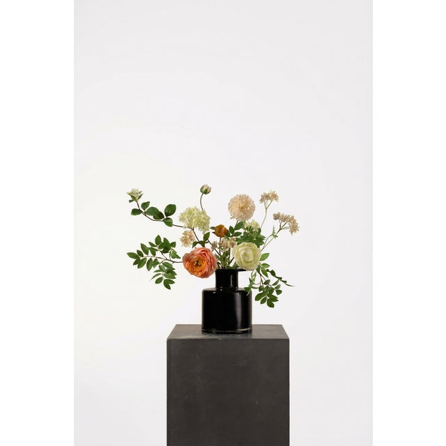 A sculptural mix of peach and soft cream blooms with lively green accents. The composition feels centered yet expressive,...