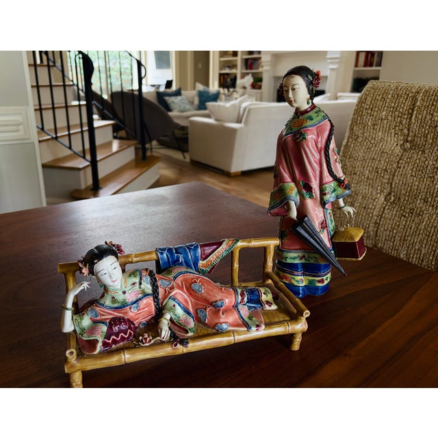 A striking pair of vintage Chinese porcelain court lady figures, beautifully modeled and richly decorated in vibrant...