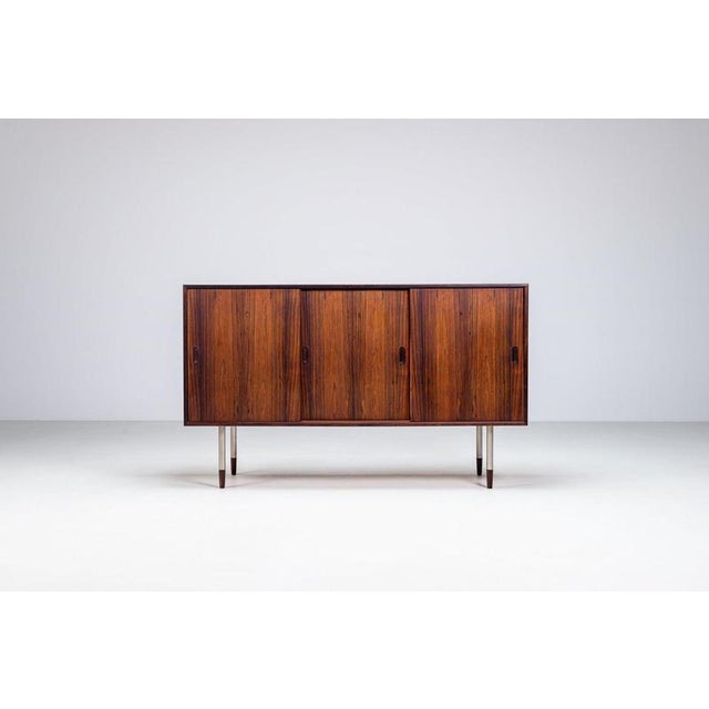 Unusual sideboard in rosewood with metal legs, Denmark 1960s. A distinctive Danish modern sideboard characterized by its...