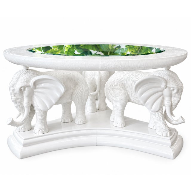 A striking sculptural coffee table featuring three beautifully detailed elephant figures finished in glossy warm white....