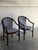 This pair of armchairs features a curved barrel frame with integrated armrests. Vintage 1980s. Crafted with dark mahogany-...