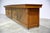 A monumental antique wooden store counter, spanning an impressive 14 feet (169.5 inches) in length. This substantial piece...