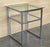This pair of side tables is made of chrome with clear glass with two shelves.