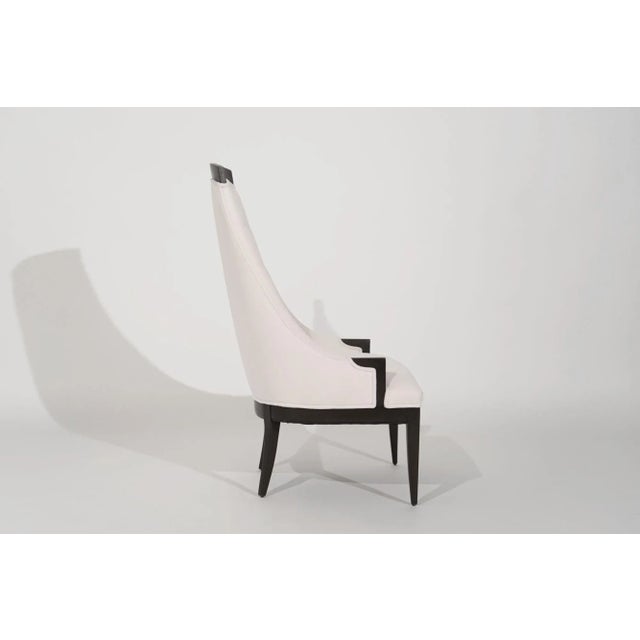 A stunning Mid-Century Modern lounge chair featuring a high-back for head support and button details. The exposed walnut...