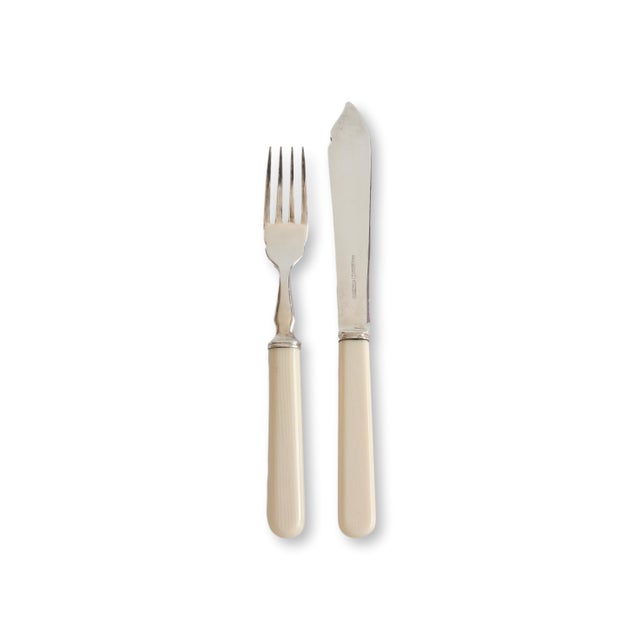 A refined midcentury fish cutlery service for eight by Mappin & Webb of London, featuring elegant faux bone handles paired...