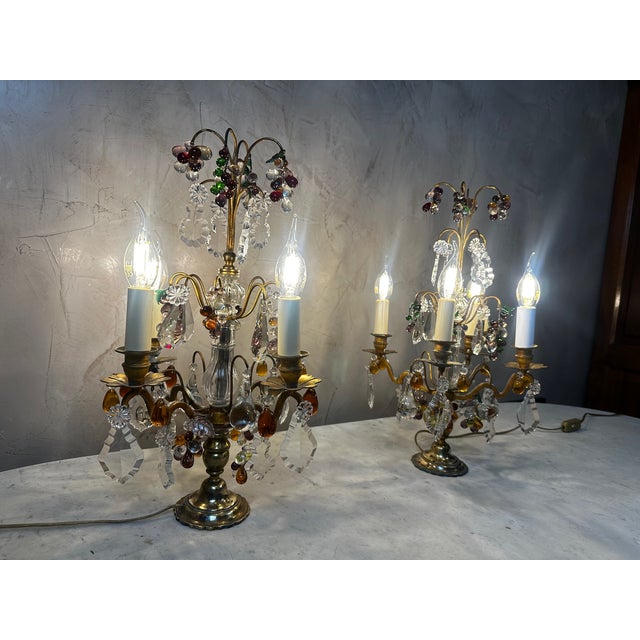 Superb pair of crystal and bronze candelabra, richly decorated with crystal drops and colorful fruit motifs. Each piece...