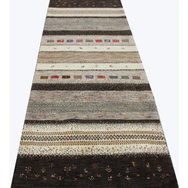 ACTUAL SIZE: 2’11” x 10’1″ PRIMARY COLOR: Brown / Ivory AGE: New MATERIALS: Wool FOUNDATION: Cotton PRODUCTION: Handwoven,...