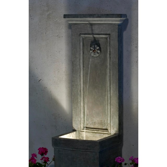 A tall wall fountain in an Alpine Stone finish. The pump kit for this fountain includes a submersible LED light for...