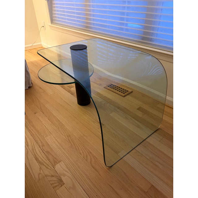 A Post-Modern two-tier waterfall edge glass cocktail table, circa 1970s. This strikingly sculptural coffee table is...