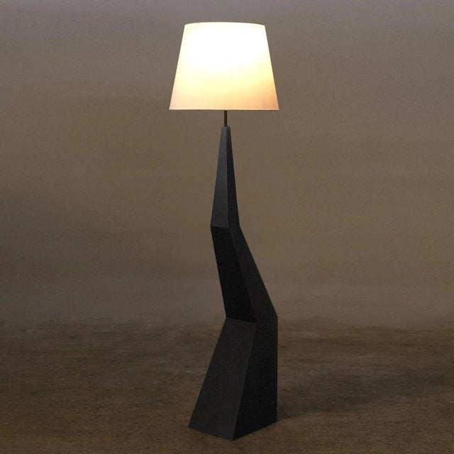 The Rhombus floor lamp features stacked geometric forms that create a striking angular effect. The base is formed of matte...