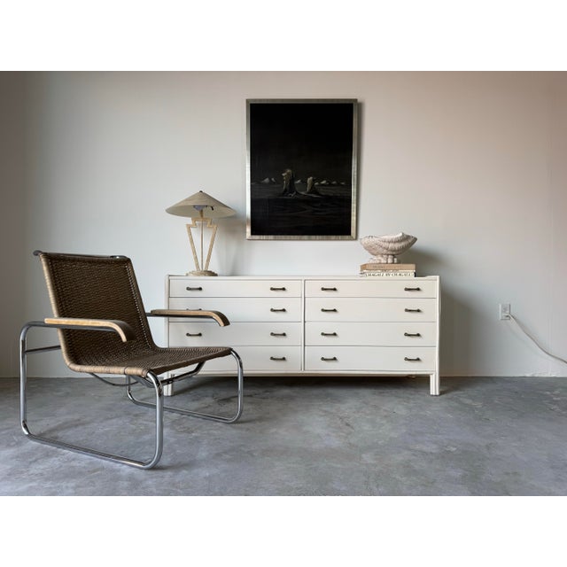 A timeless and elegant 1970s vintage dresser by John McGuire, crafted with a harmonious blend of wood and rattan, and...