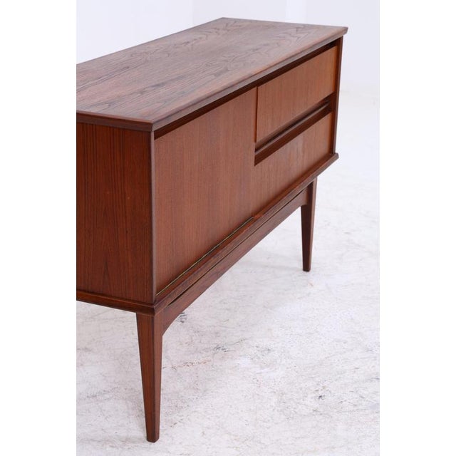 Vintage teak chest of drawers from the 1960s with a clean, timeless design. The combination of two drawers and a cabinet...