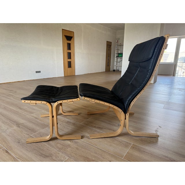 Authentic Siesta Fiora high-back lounge chair with matching ottoman in black leather and bentwood frame. Includes the...