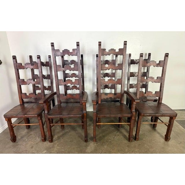 A handsome and sculptural set of eight Spanish Colonial Revival dining chairs, dating to the mid-20th century (circa 1940)...
