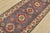 A tribal Caucasian Kazak runner hand-knotted with fine wool on a cotton foundation. This rug features medallions...