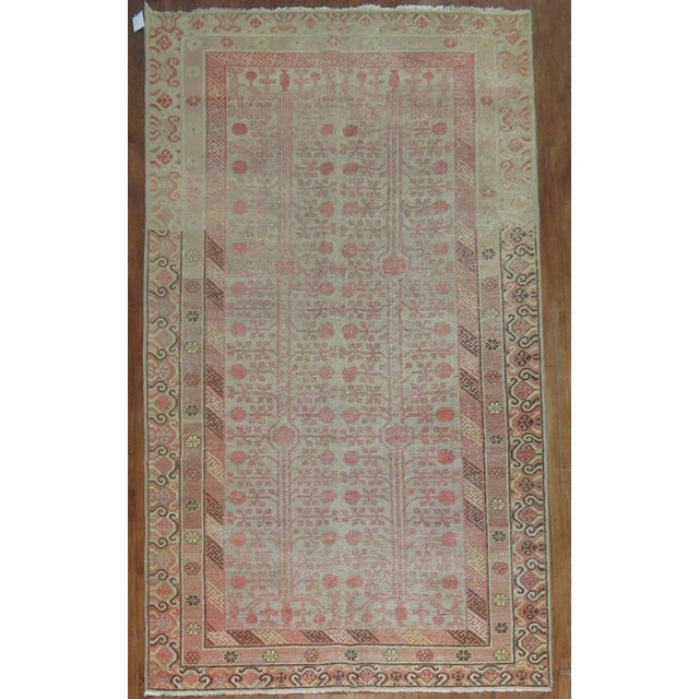 an early 20th century worn East Turkestan khotan rug with a pomegranate design 6'3'' x 13'