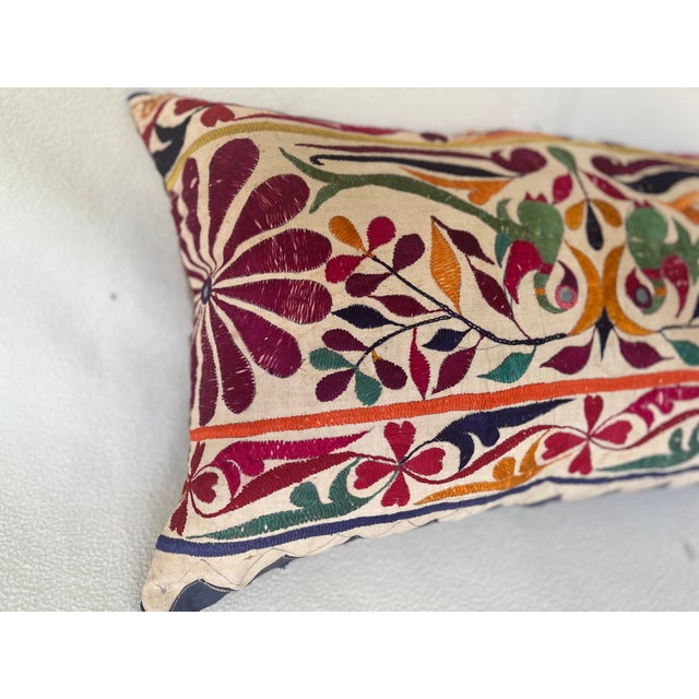 Elegant decorative pillow upholstered in a richly patterned Uzbek textile, featuring charming floral flowerhead motifs and...