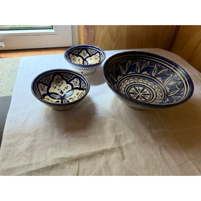 A graduated set of three hand-painted Safi ware bowls from Morocco — one large serving bowl and two smaller matching bowls...