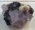 Old fluorite mineral rock specimen. Pale purple crystals with darker specks and textural cream white accents in a dark...