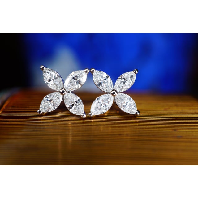 Pair of pushback earrings featuring four marquises cut naturally mined diamonds set in platinum in a floral design. All...