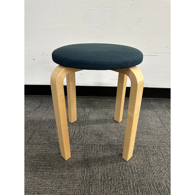The pre-owned Artek Aalto Stool 60 is a versatile and stackable design, featuring a blue fabric upholstery and a maple...