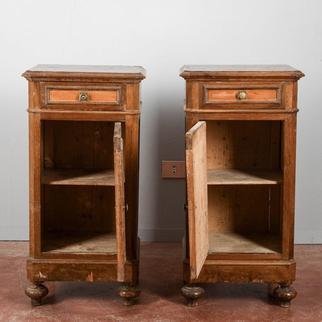 This pair of nightstands is an example of vintage furniture, likely dating back to the early 1900s, in need of...