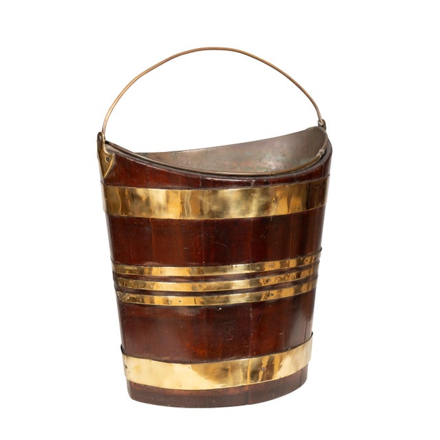 Navette shape with brass handle and liner. Brass strapping on sides.