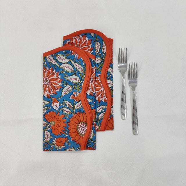 A beautiful set of printed blue and orange flower botanical napkins with piped edge. This product is made from soft cotton...