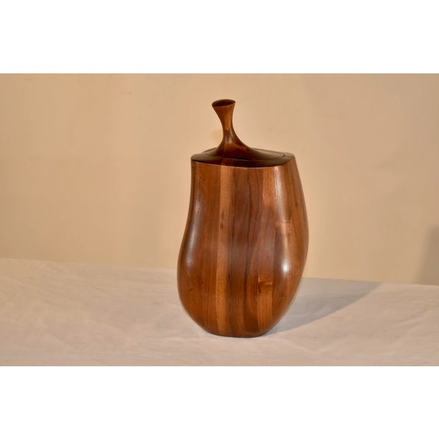 Sleek mid-century turned treen jar with lid. The jar is made from mahogany and walnut and is uniquely shaped. The wood has...