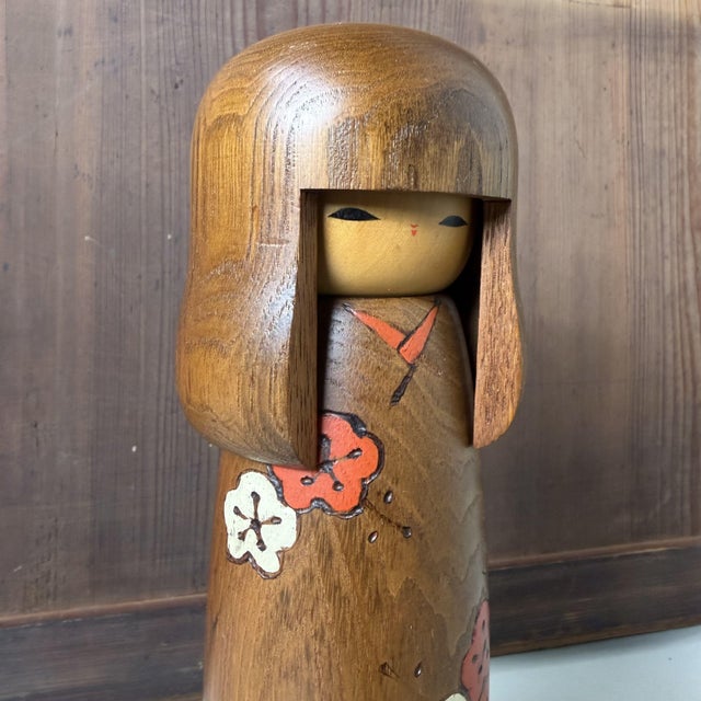 This vintage Japanese kokeshi by Usaburo has an elegant, elongated form with a striking oversized hairstyle, in which the...