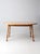 This vintage farmhouse dining table features a striped laminated wood top paired with turned legs in a warm natural...