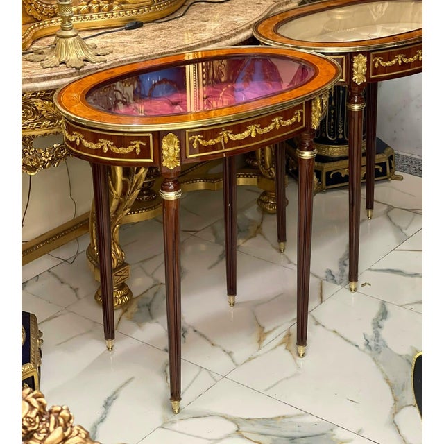 Showcase your treasured collectibles in timeless French elegance with this exquisite Louis XVI oval display side table....