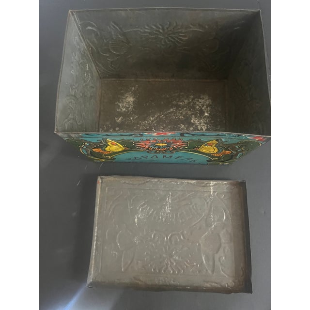 This is an interesting Russian Tin Box that held caramel candies. It has beautiful colors and designs and lettering in the...