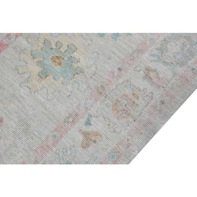 This modern Turkish Oushak rug is a stunning piece of art that has been handwoven using traditional techniques by skilled...