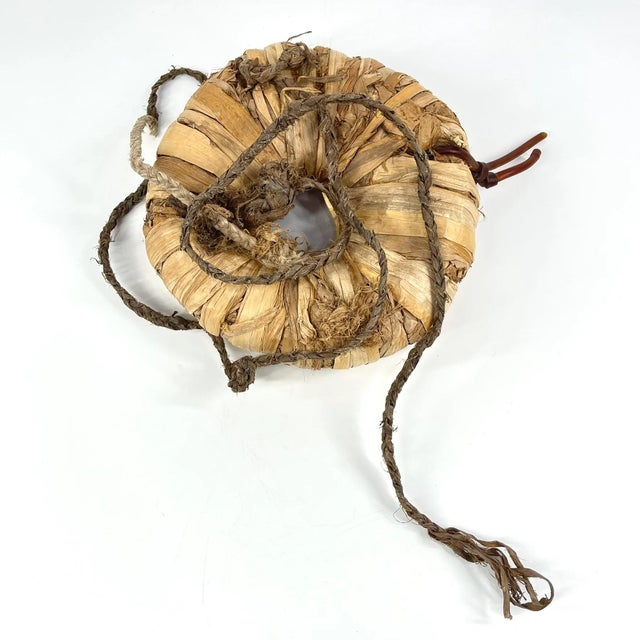 African head ring handcrafted from wrapped plant fibers and dried leaves. Traditionally used as a cushion to support and...
