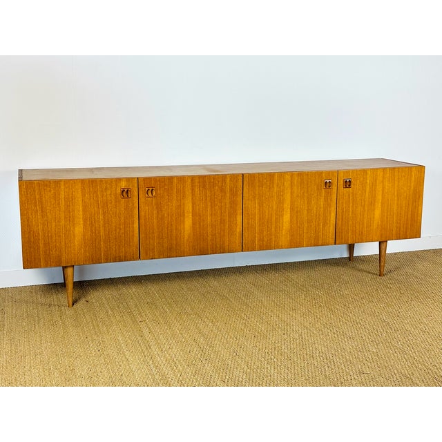 Vintage Scandinavian teak sideboard dating from the 1960s, featuring four storage doors with minimalist shelves and...
