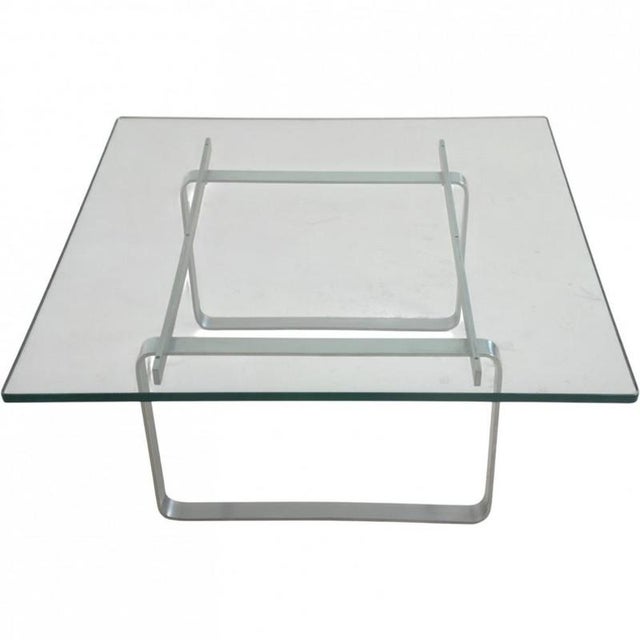 Hans Wegner JH106 coffee table with a table top of glass and a frame of steel. The table is from the 1980s and appears in...