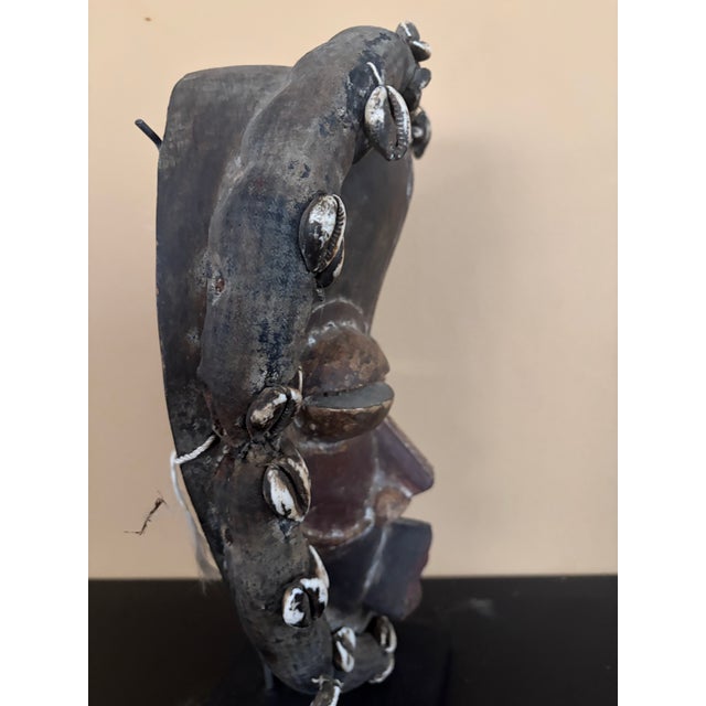 This is African Dan mask from the Ivory Coast, from the 20th century. It is made of wood, cowrie shells and textiles. It...